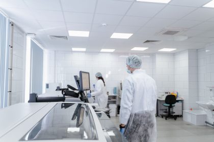 Profissionais realizam pesquisas em um laboratório farmacêutico moderno, equipado com instrumentos científicos.