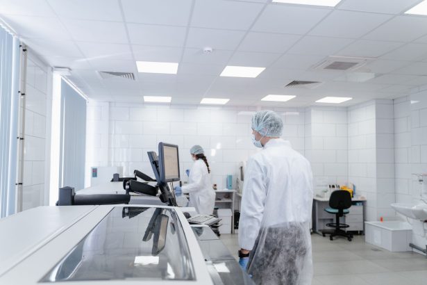 Profissionais realizam pesquisas em um laboratório farmacêutico moderno, equipado com instrumentos científicos.