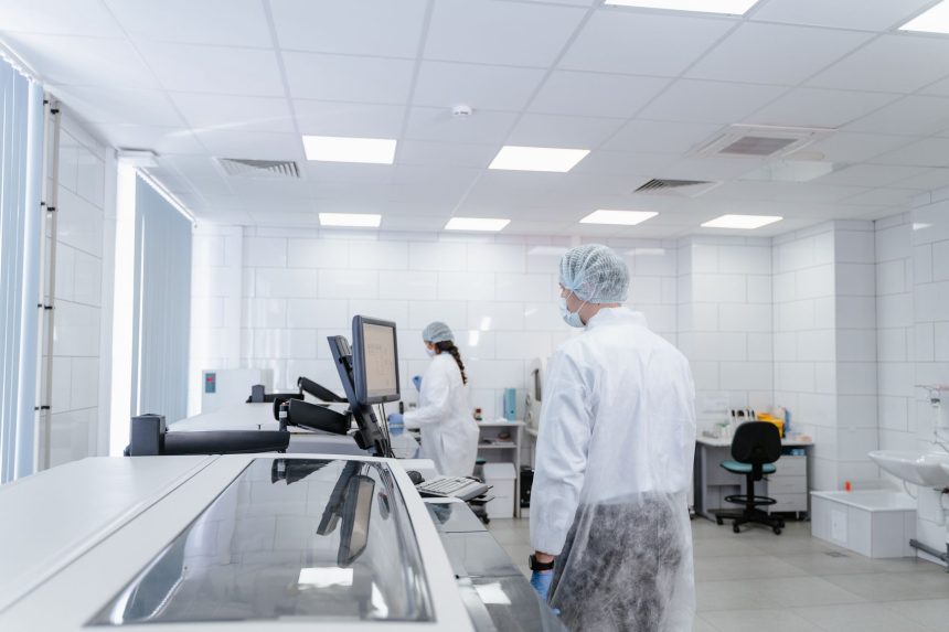 Profissionais realizam pesquisas em um laboratório farmacêutico moderno, equipado com instrumentos científicos.