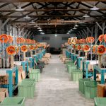 Galpão industrial amplo com máquinas e equipamentos de produção.