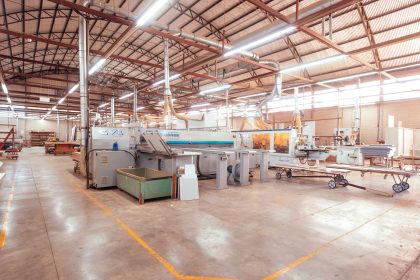 Interior amplo e organizado de uma fábrica industrial moderna, com máquinas e estruturas de produção.