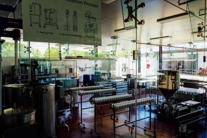 Interior de uma moderna fábrica de alimentos, com maquinário industrial e linha de processamento.