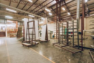 Interior de uma fábrica industrial ampla e iluminada, com máquinas e estruturas de armazenamento.