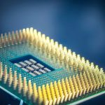 Close de um chip de processador de computador com contatos dourados sobre fundo azul.