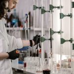 Pesquisadores de jaleco trabalham com tubos de ensaio em um laboratório moderno.